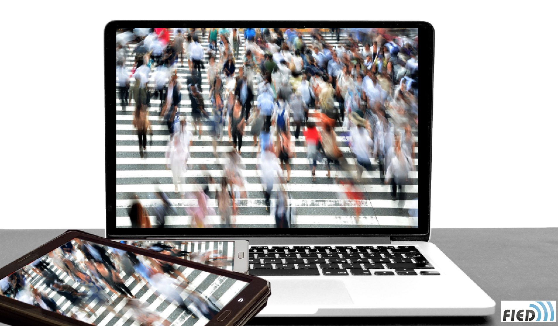 Photo d'un laptop avec des personnes floues qui traversent un passage clouté.